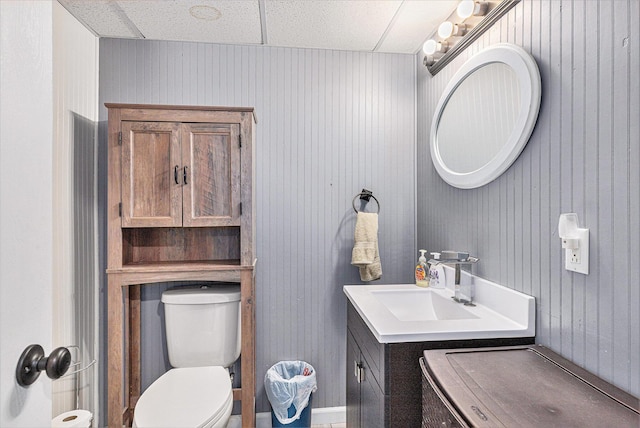 bathroom featuring vanity, a drop ceiling, and toilet