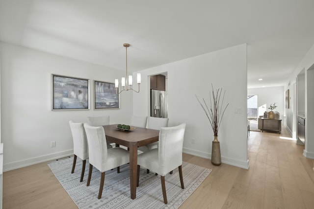 dining room featuring light hardwood / wood-style flooring and a notable chandelier