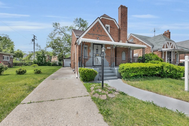 bungalow with an outbuilding, a garage, and a front lawn