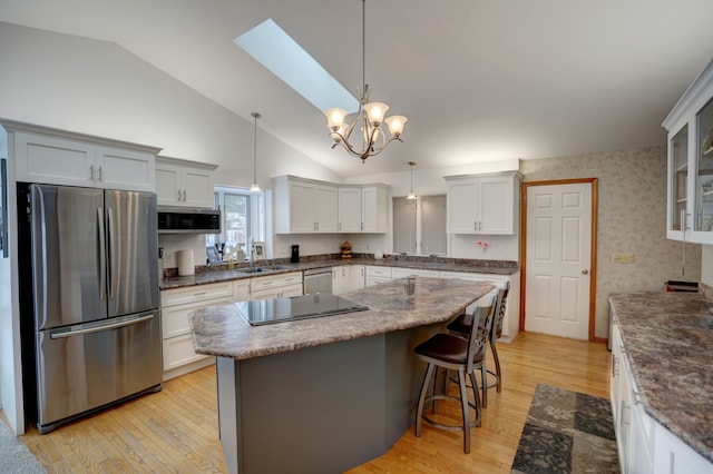 kitchen with hanging light fixtures, white cabinetry, and stainless steel appliances