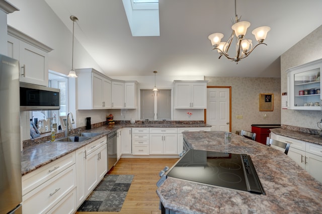 kitchen featuring appliances with stainless steel finishes, decorative light fixtures, sink, and white cabinetry