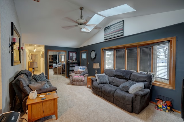 living room with light carpet, vaulted ceiling with skylight, and ceiling fan