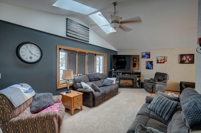 carpeted living room featuring ceiling fan and vaulted ceiling with skylight