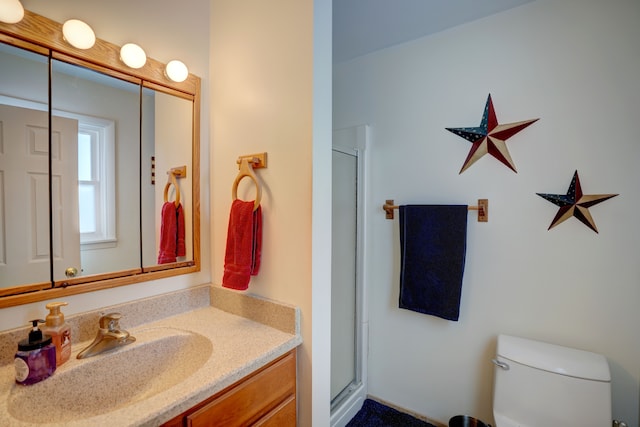 bathroom with toilet, vanity, and walk in shower