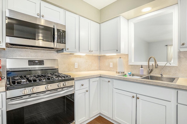 kitchen featuring white cabinetry, sink, decorative backsplash, and appliances with stainless steel finishes