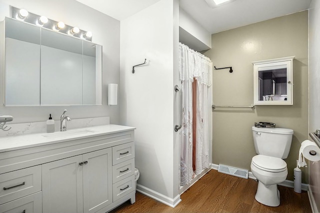 bathroom with wood-type flooring, toilet, and vanity