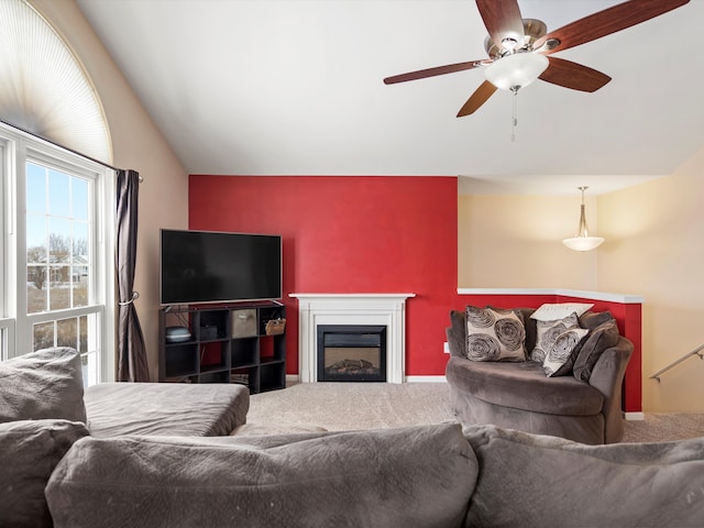 living room featuring carpet floors, lofted ceiling, a fireplace, and a ceiling fan