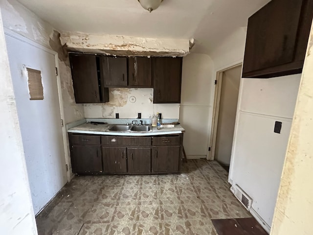 kitchen featuring dark brown cabinets and sink