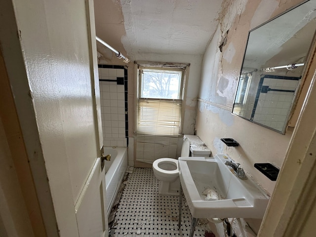 full bathroom with sink, tiled shower / bath combo, and toilet