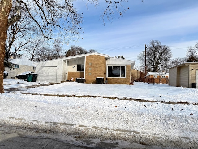 snow covered property featuring brick siding