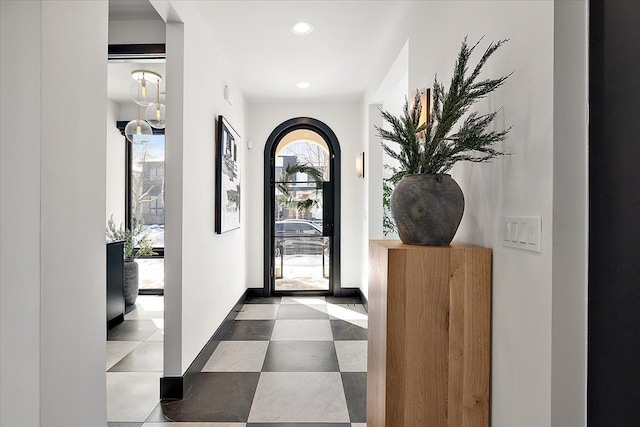 foyer with arched walkways, baseboards, and recessed lighting