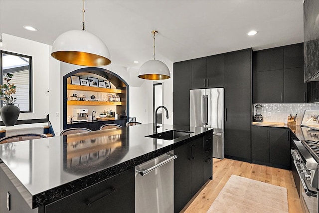 kitchen with premium appliances, a large island, dark cabinets, and decorative light fixtures