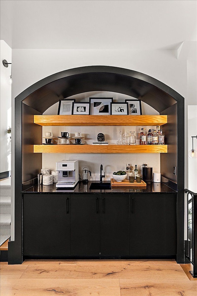 bar featuring wine cooler, bar area, a sink, and wood finished floors