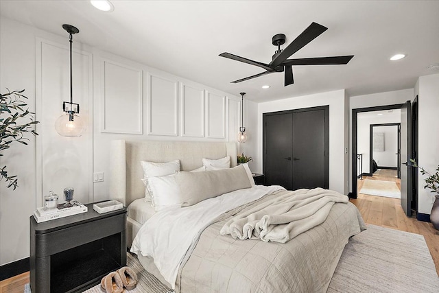 bedroom featuring ceiling fan, a closet, recessed lighting, and light wood-style floors