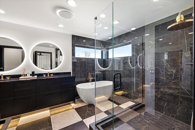 bathroom with recessed lighting, a sink, a soaking tub, double vanity, and a stall shower