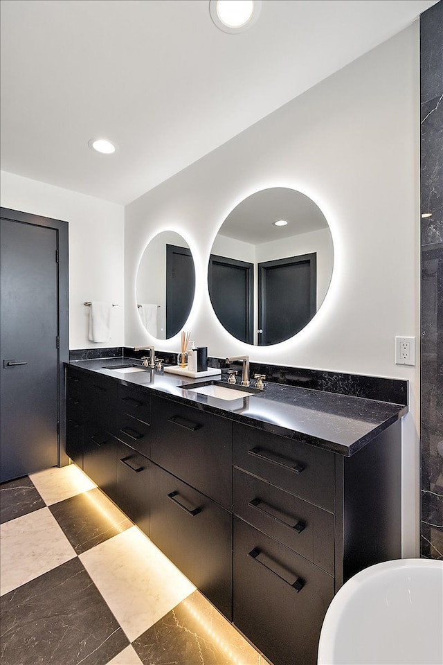 full bathroom with double vanity, a soaking tub, a sink, and recessed lighting