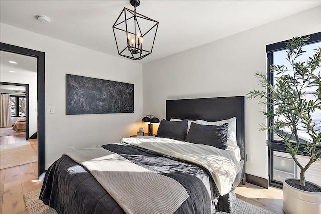 bedroom featuring light wood finished floors and a notable chandelier