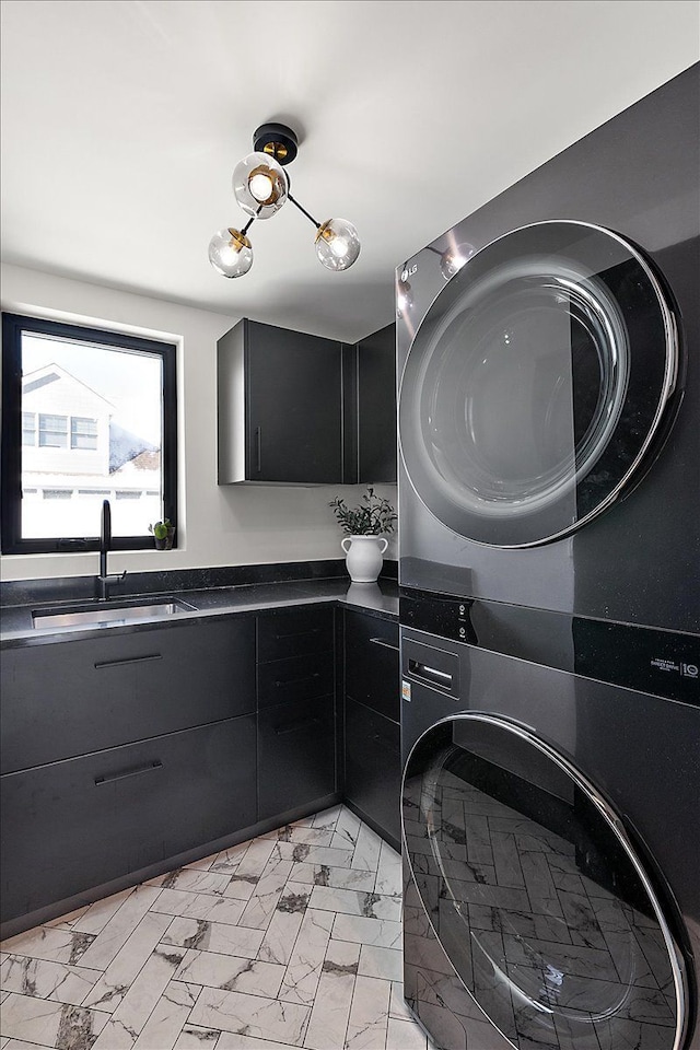 bathroom featuring marble finish floor, vanity, and stacked washer and clothes dryer