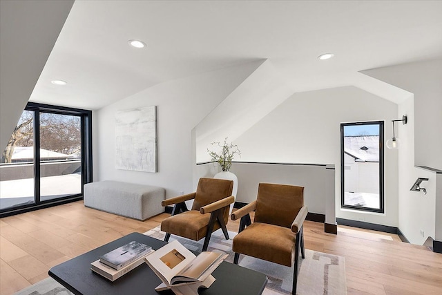 interior space featuring light wood-type flooring, lofted ceiling, and recessed lighting