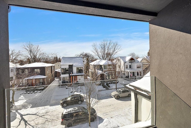 snow covered back of property with a residential view