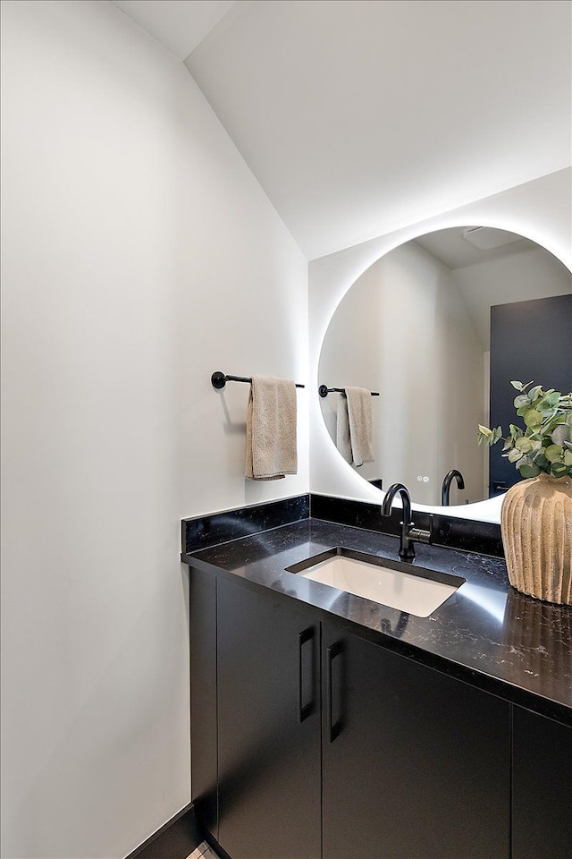 bathroom with lofted ceiling and vanity