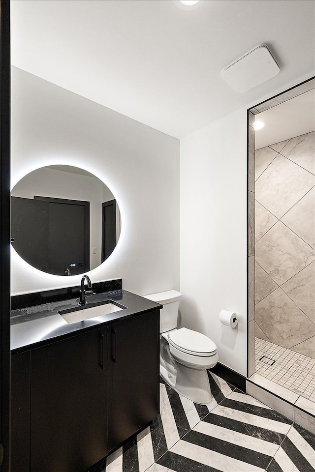 bathroom with a stall shower, vanity, and toilet