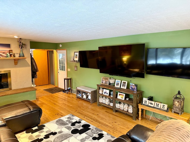 living room featuring light hardwood / wood-style flooring and a textured ceiling