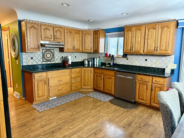 kitchen with sink, light hardwood / wood-style flooring, black electric cooktop, stainless steel dishwasher, and dark stone counters