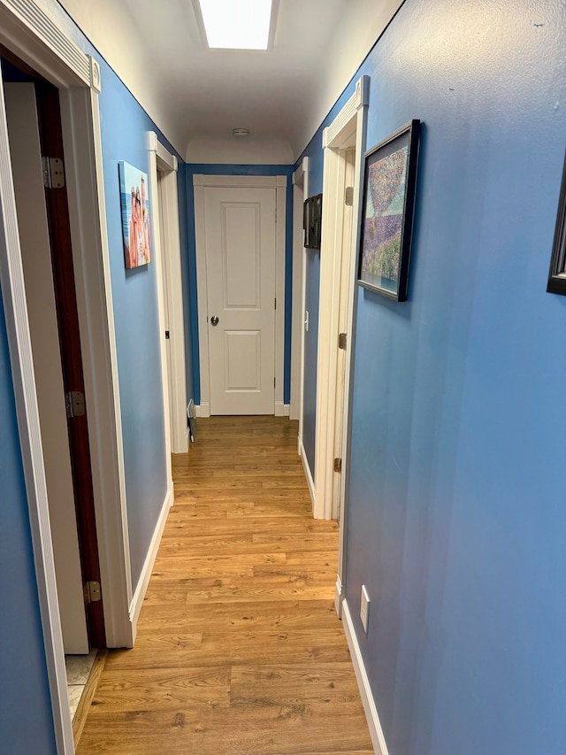 corridor with light hardwood / wood-style flooring