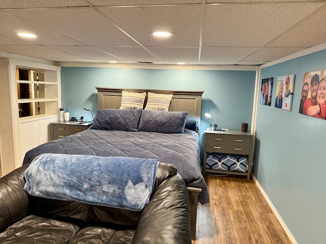 bedroom featuring a paneled ceiling and light hardwood / wood-style flooring