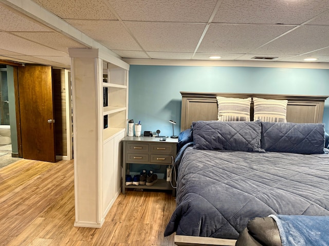 bedroom featuring a paneled ceiling and light wood-type flooring