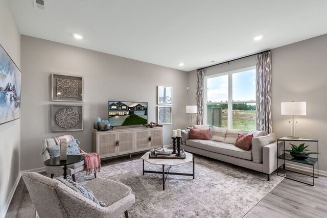 living area featuring baseboards, recessed lighting, wood finished floors, and visible vents