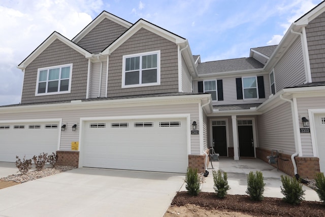 view of front of house featuring an attached garage, concrete driveway, and brick siding