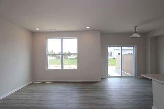 unfurnished living room featuring recessed lighting, a healthy amount of sunlight, and wood finished floors