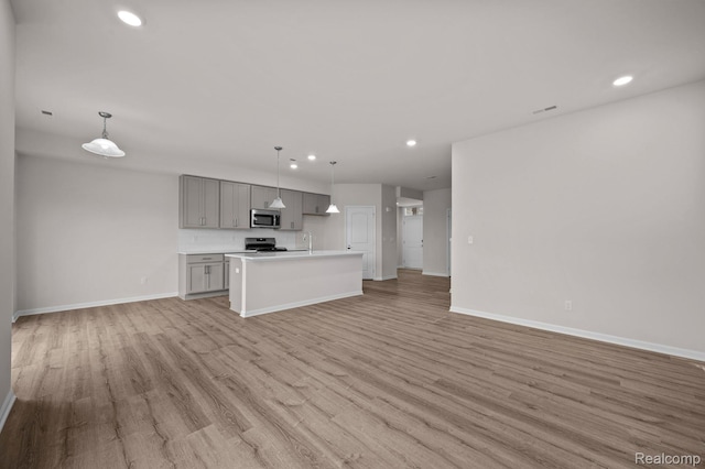 2302 Mill Ln, Saline, MI 48176 - kitchen with appliances with stainless steel finishes, gray cabinets, open floor plan, a sink, and recessed lighting