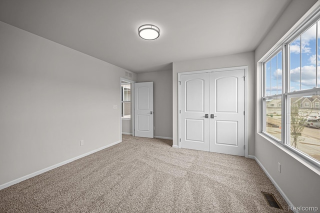 2302 Mill Ln, Saline, MI 48176 - unfurnished bedroom featuring carpet floors, multiple windows, and baseboards