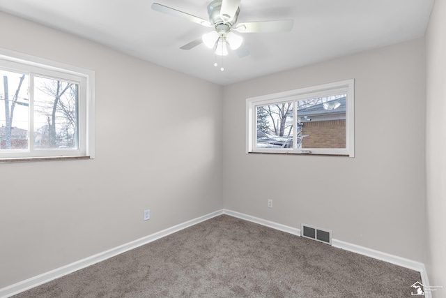 carpeted empty room with a healthy amount of sunlight and ceiling fan