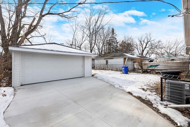 snow covered garage featuring cooling unit