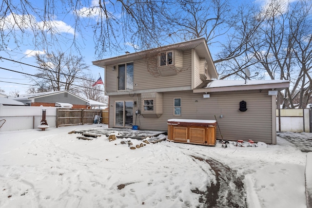 snow covered property featuring a hot tub