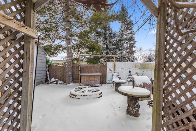 snow covered patio featuring a fire pit