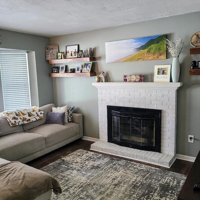 living room with a fireplace, dark wood-type flooring, and a textured ceiling