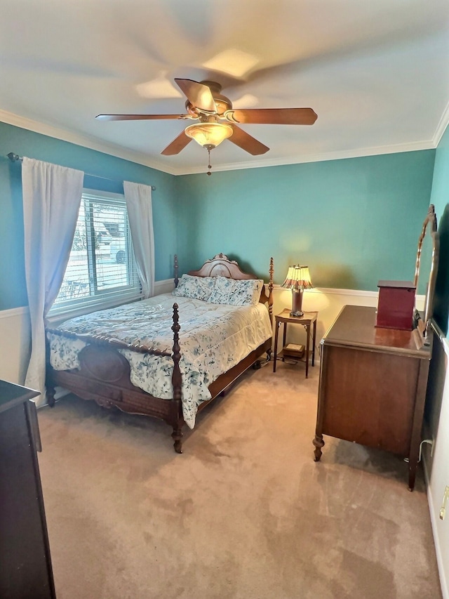 carpeted bedroom featuring crown molding and ceiling fan