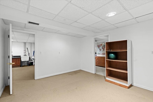 basement featuring sink and a paneled ceiling