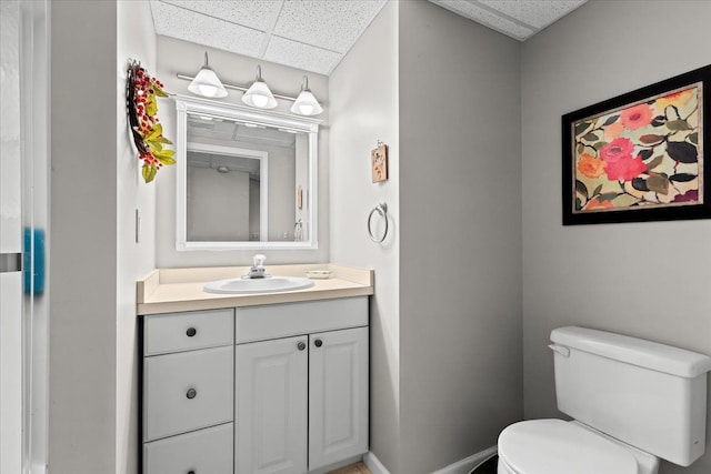 bathroom with vanity, a drop ceiling, and toilet