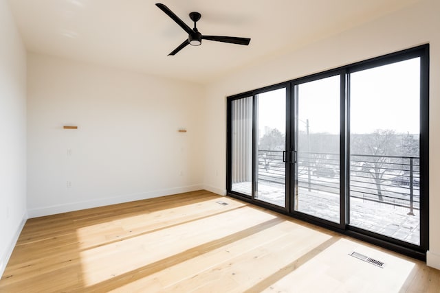 spare room featuring hardwood / wood-style flooring, plenty of natural light, and ceiling fan