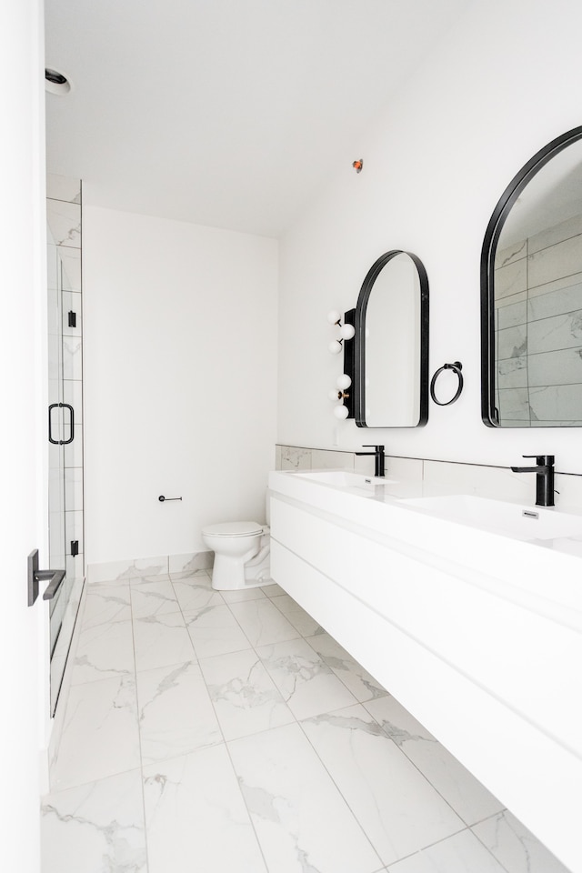 bathroom with vanity, toilet, and a shower with door