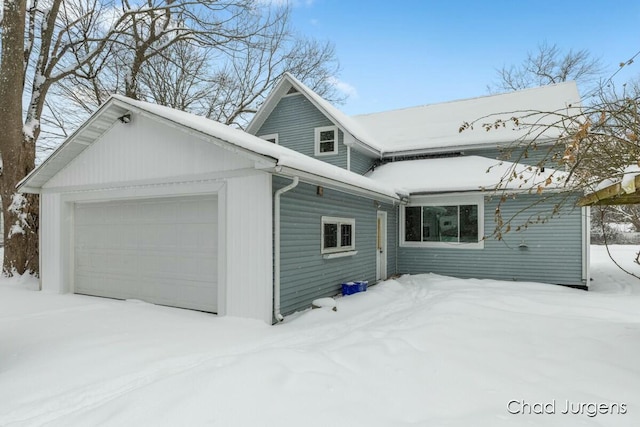 snow covered property with a garage