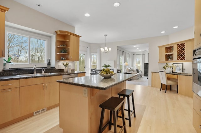 kitchen featuring a breakfast bar area, visible vents, open shelves, a sink, and a center island