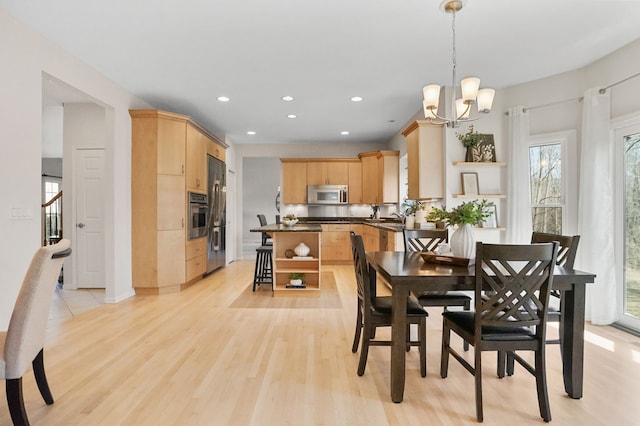 dining space with stairway, recessed lighting, light wood-style floors, and a chandelier