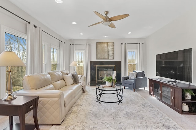 living area with recessed lighting, a fireplace, ceiling fan, and carpet floors